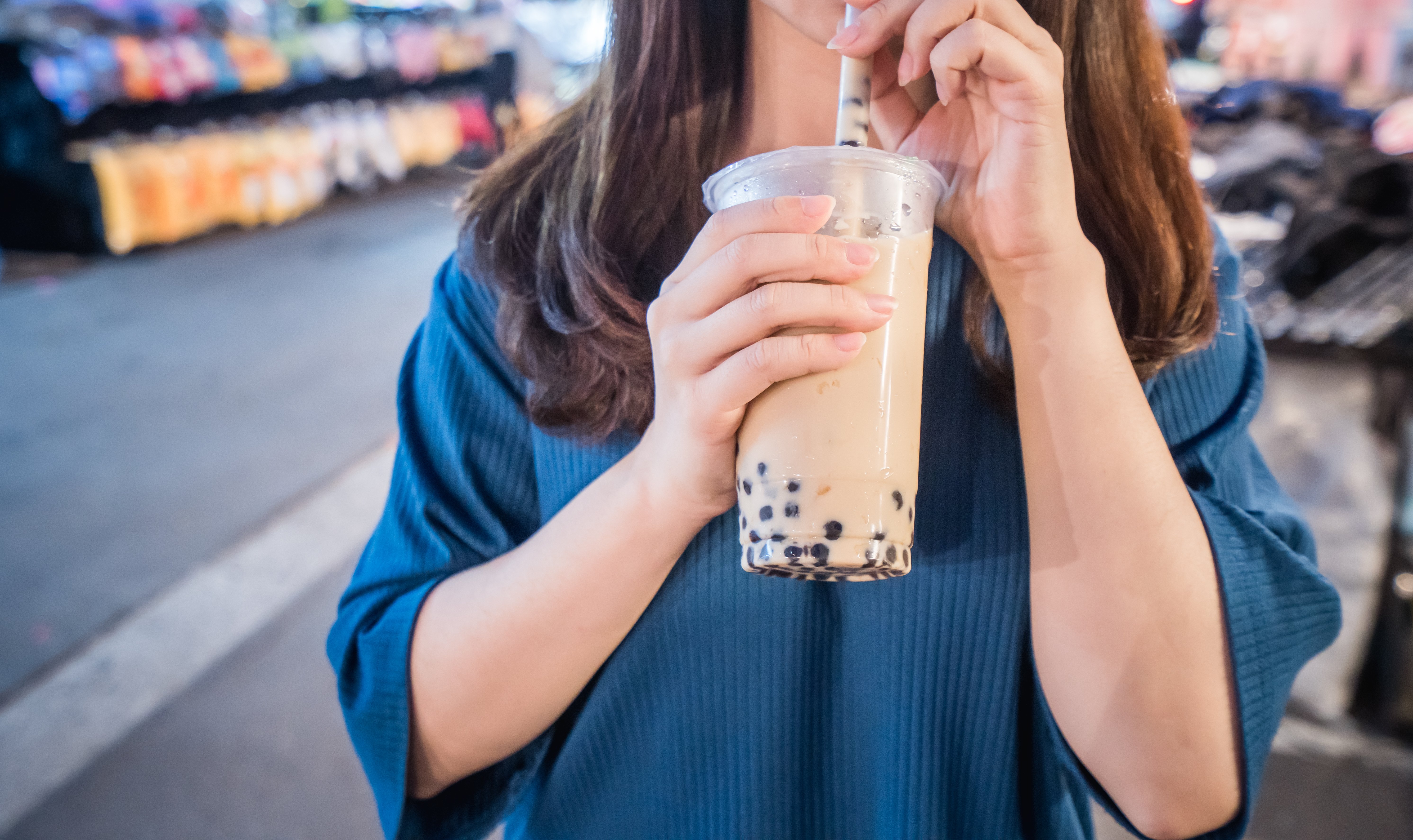 young-woman-is-drinking-plastic-cup-bubble-milk-tea-with-straw-night-market-taiwan-taiwan-delicacy-close-up